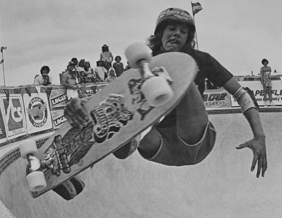 Doug Marker grabs air over a contest pool with crowd and sponsor banners in Southern California.