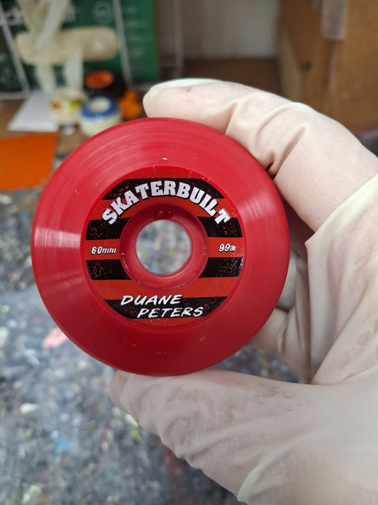 Duane Peters 60mm x 99A blood red double conical skateboard wheels with Skater Built branding, side view pack of four